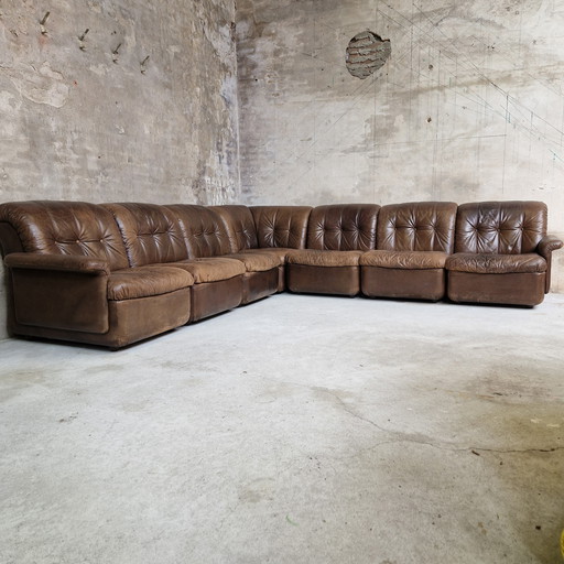 Sofá modular de los años 70 con elementos marrones y sofá de cuero.