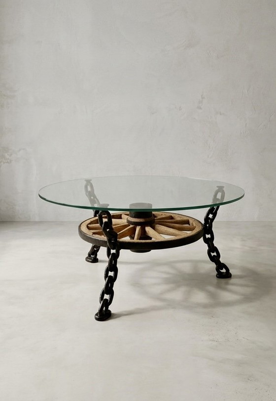 Image 1 of Tafel in de vorm van een wagenwiel met een massief glazen blad.