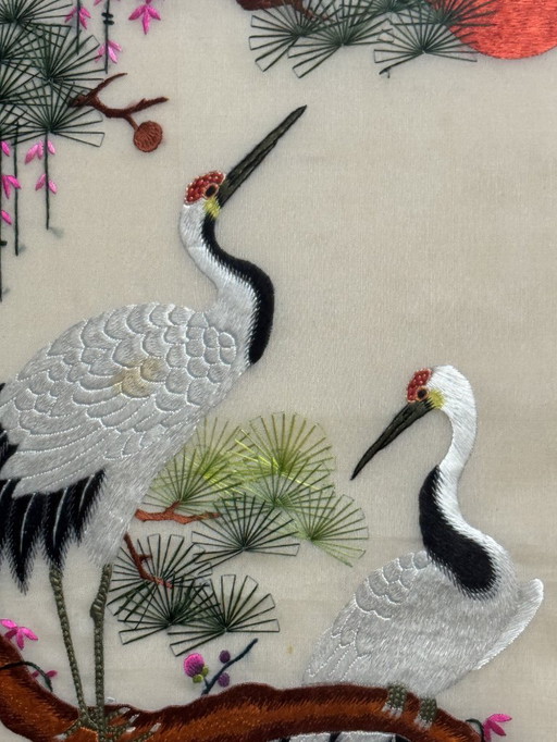 Pannello ricamato giapponese con gru, fiori di ciliegio e sole nascente, XX secolo.