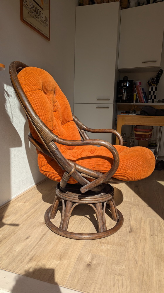 Image 1 of Draaibare rotanstoel uit de jaren 70 met oranje corduroy kussen