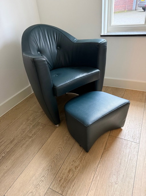 Sillón Leolux Carabita con otomana, tapizado en piel verde oscuro.