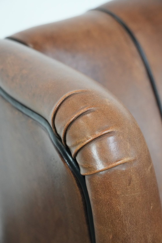 Image 1 of Poltrona a orecchioni in pelle di pecora con profili neri, in buone condizioni.