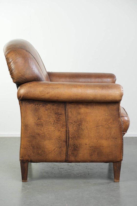 Comoda poltrona in pelle di pecora, dal carattere deciso, rifinita con borchie decorative e una splendida (photo 3 of 13)
