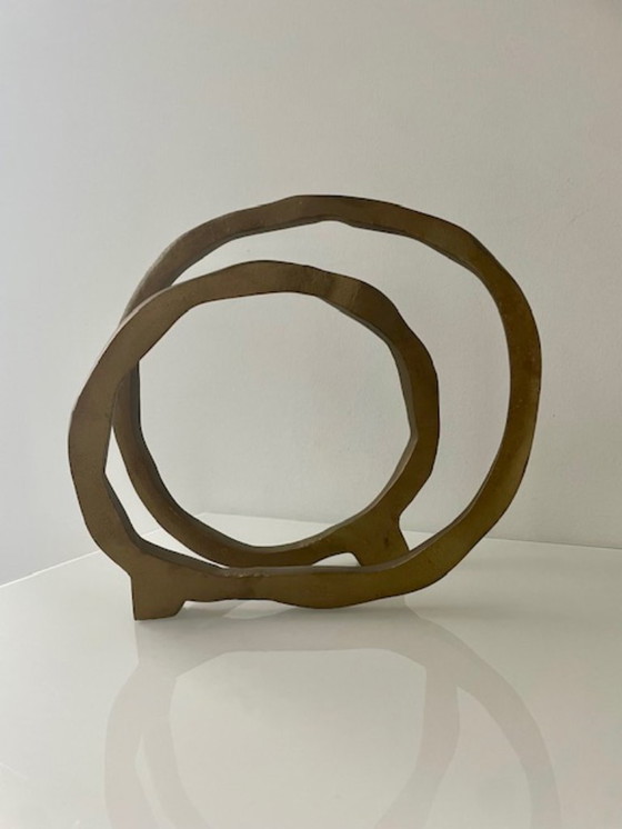 Image 1 of Escultura de diseño con forma de anillo abierto en oro mate.