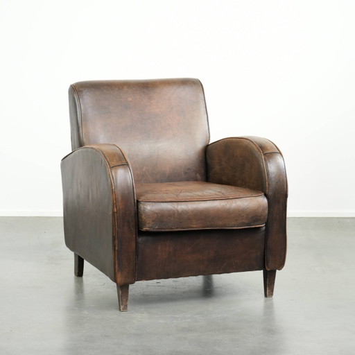 Fauteuil confortable en cuir de mouton avec passepoil assorti et un look intemporel