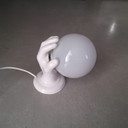 Lampada da parete scultorea in porcellana, mano in ceramica con sfera in vetro
