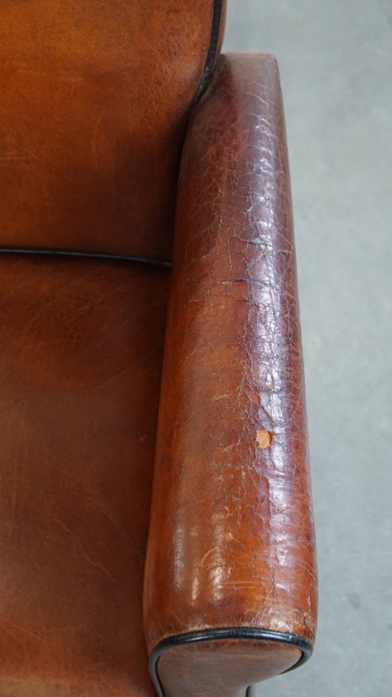 Image 1 of 2 x Vintage schapenleren eetkamerstoel met zwarte biezen op wieltjes