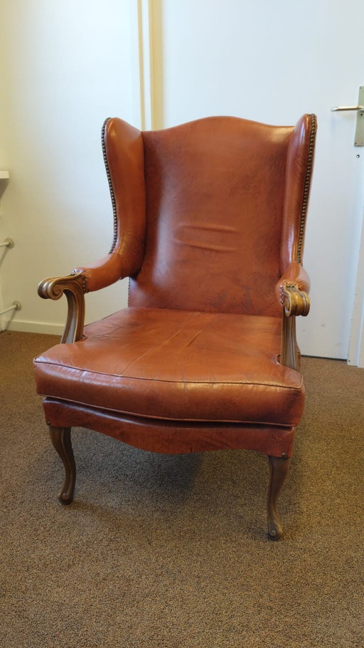 ElVintage ear armchair executed in cognac sheep leather with elegant wood tooled armrest and legs