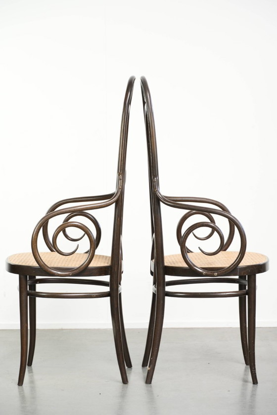 Image 1 of 2 chaises vintage originales Thonet, modèle Long John, avec accoudoirs, dossier haut, assise et dossier en sangles.
