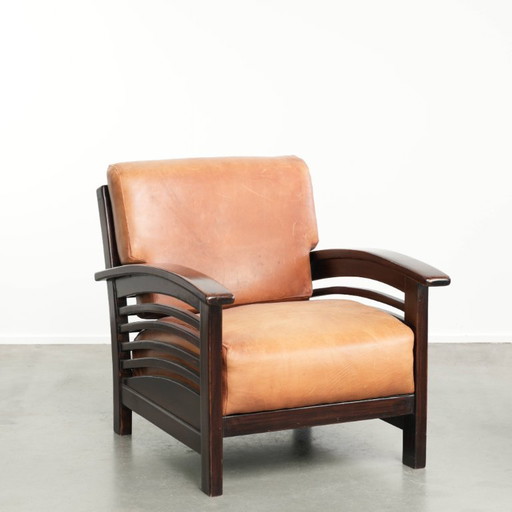 Comfortable and beautiful cognac-colored cowhide leather armchair in luxurious Art Deco design