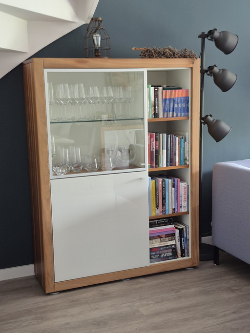 Table haute Hülsta Xelo Design – Bois de noyer, verre blanc brillant et vitrine