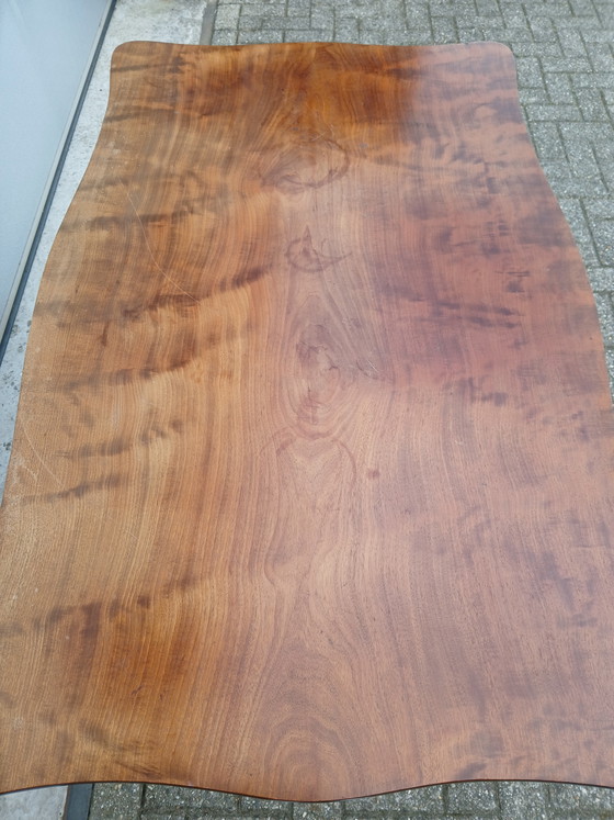 Image 1 of The antique dining table is made of mahogany and has a Louis XV style.