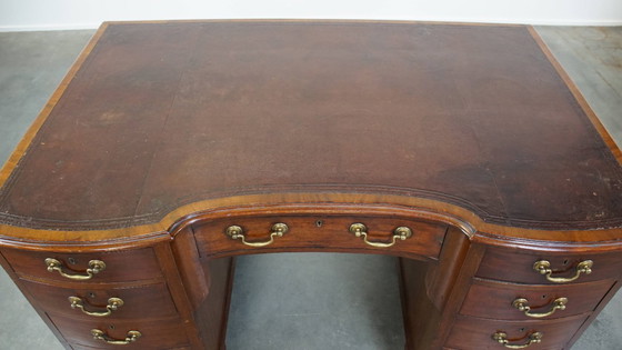 Image 1 of Luxurious and antique English wooden desk from the late 19th century with a leather top and a curved front.