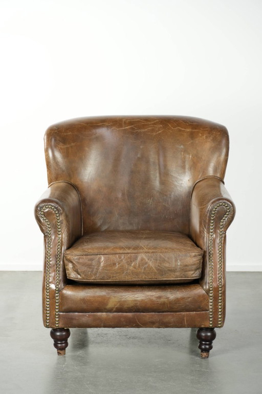 Stoere rundleren fauteuil in een mooi subtiel formaat met een prachtig patina