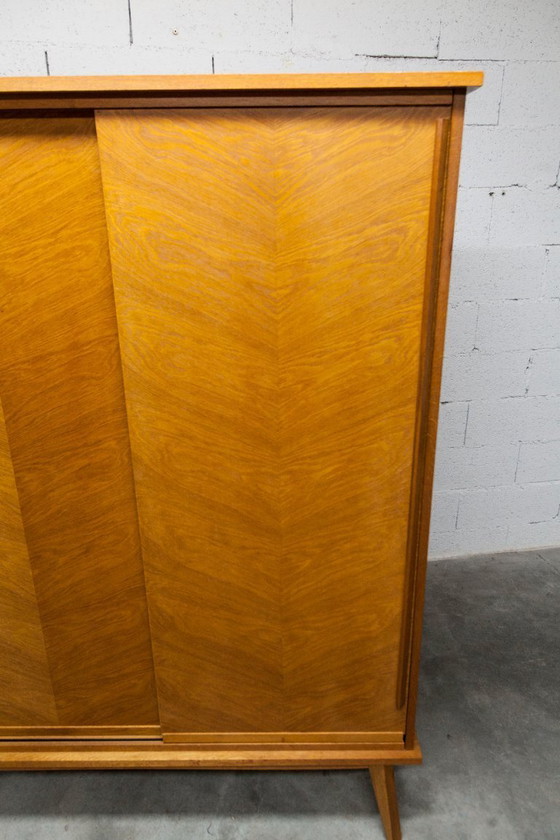 Image 1 of Kledingkast uit de jaren 50 met kompasvormige poten, schuifdeuren en een nieuw bovenblad.