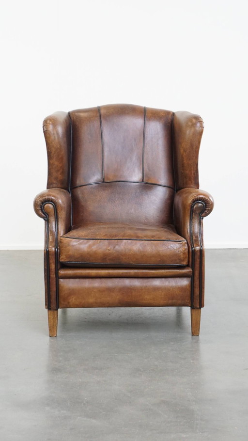 Fauteuil à oreilles en cuir de mouton avec finition passepoilée noire