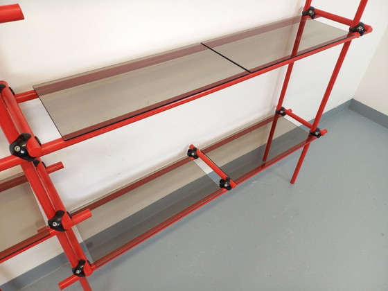 Image 1 of Vintage Italiaanse Bauhaus-boekenkast van rood metaal en rookglas uit de jaren 70.