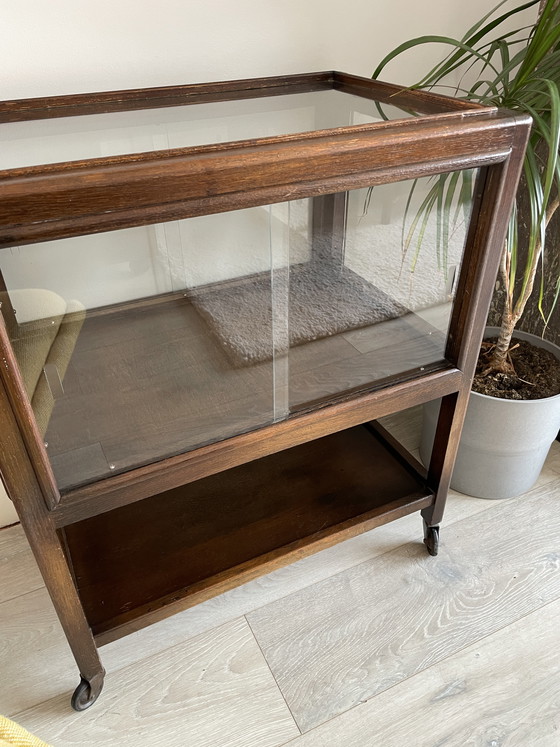 Image 1 of Eikenhouten kast uit het midden van de vorige eeuw met schuifdeuren van glas op wielen (vitrinekast / cocktailkast)