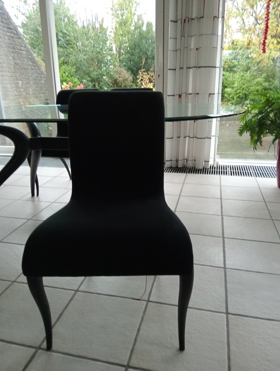 Image 1 of Mesa de comedor ovalada de cristal con 4 sillas negras a juego.