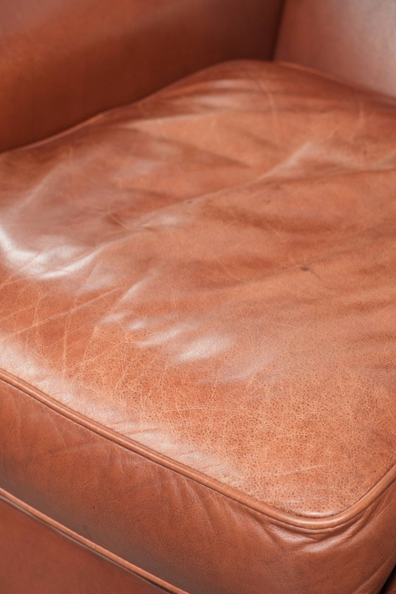 Image 1 of Comoda poltrona a orecchioni in pelle bovina color cognac in stile inglese.