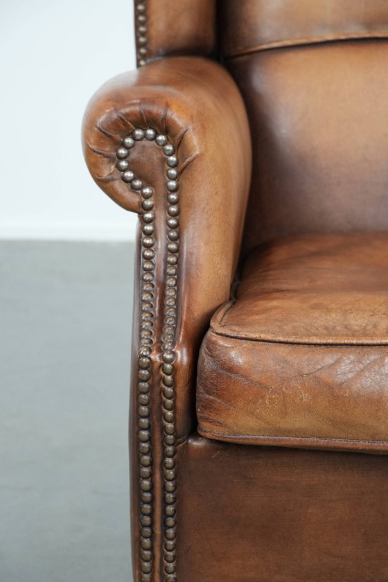 Image 1 of Sillón orejero de piel de oveja acabado con clavos decorativos