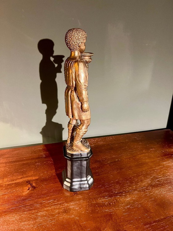 Image 1 of Rarität! Kerzenständer mit der Abbildung eines orientalischen Jünglings aus Messing auf schwarzem Porzellanfuß, 20. Jahrhundert 