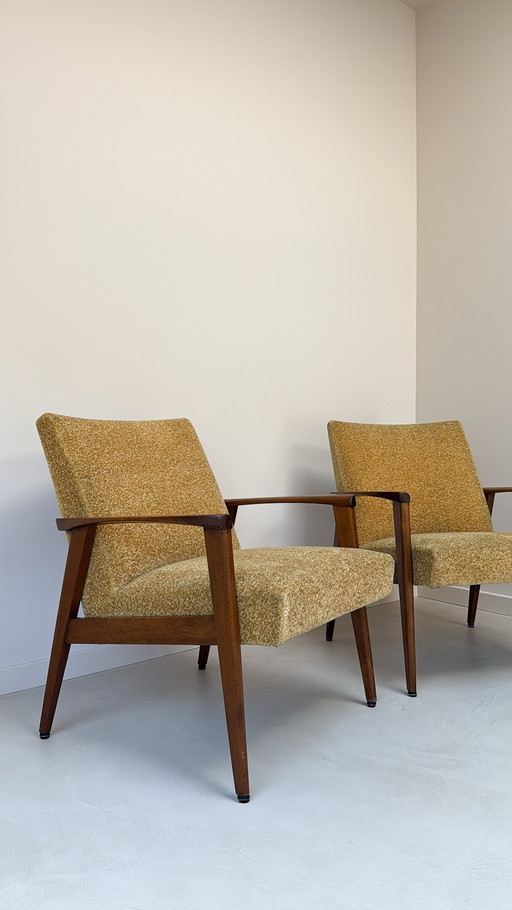 Two vintage teak wood armchairs with fabric upholstery