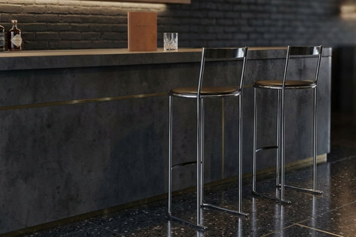 Een paar vintage krukjes uit de jaren 70 - minimalistisch design in chroom en leer.