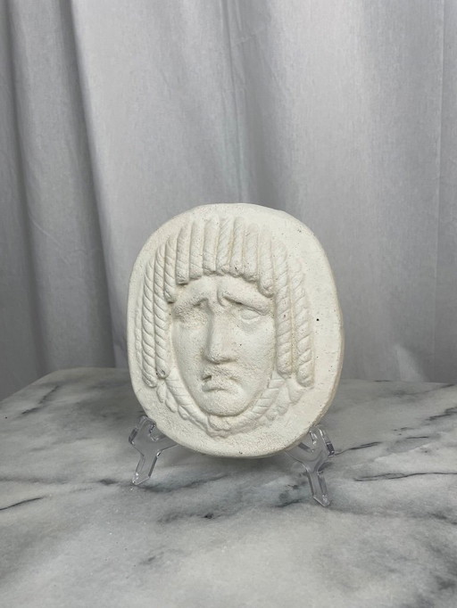 Antique mask-style low-relief face
