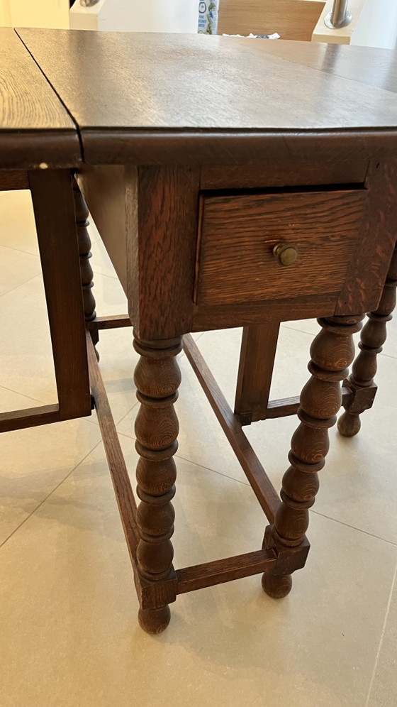 Image 1 of Mesa plegable de roble macizo estilo neojacobino inglés con patas abatibles.
Circa 1925–1940
