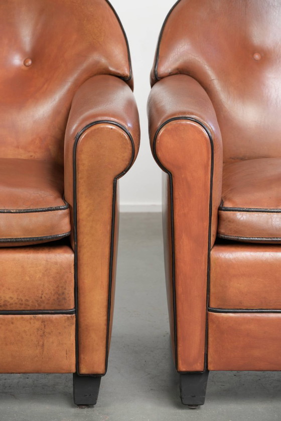 Image 1 of 2 poltrone di design Bart van Bekhoven in pelle di pecora con schienale arrotondato e profili neri.