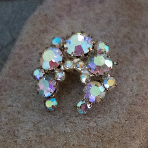 Broche vintage Aurore Boréale : bijou ancien en forme de fer à cheval orné de strass irisés