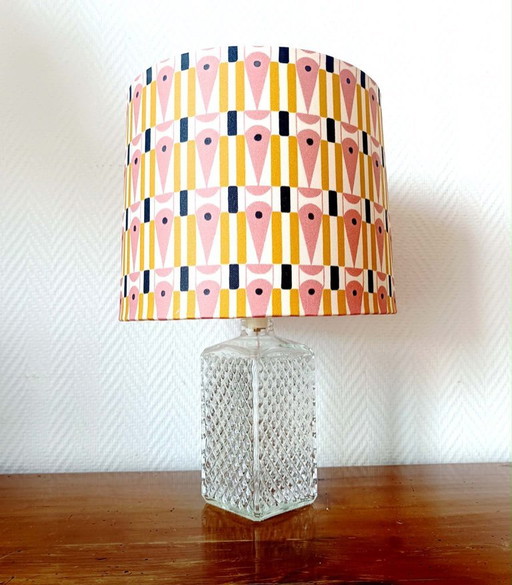 Lamp in de vorm van een whiskykaraf met een abstracte lampenkap.