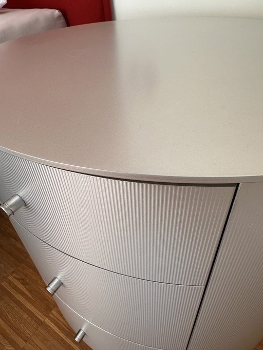 Comodino ovale in legno massello con rivestimento in alluminio spazzolato opaco