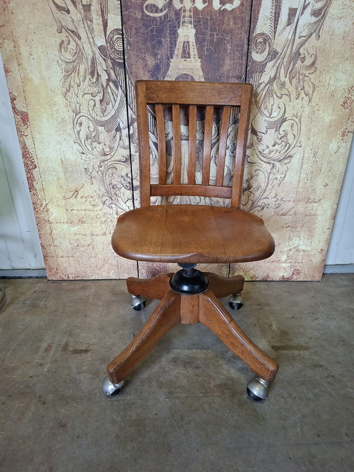 Antieke verstelbare, draaibare bureaustoel van eikenhout gemaakt door de H. Krug Furniture Company afm.42x50cm en 78cm hoog.