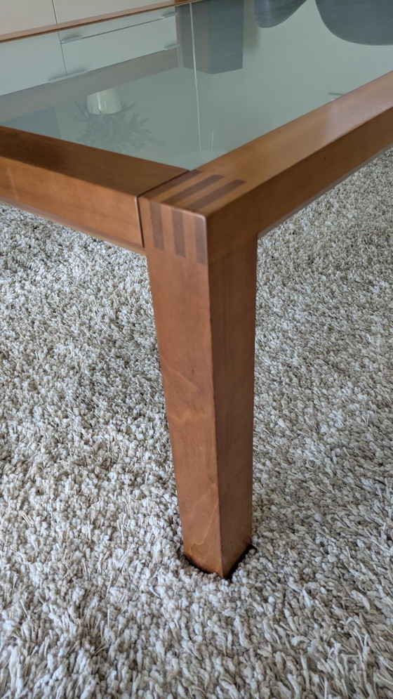 Image 1 of cherry wood red coffee table with sleek glass top from 1996