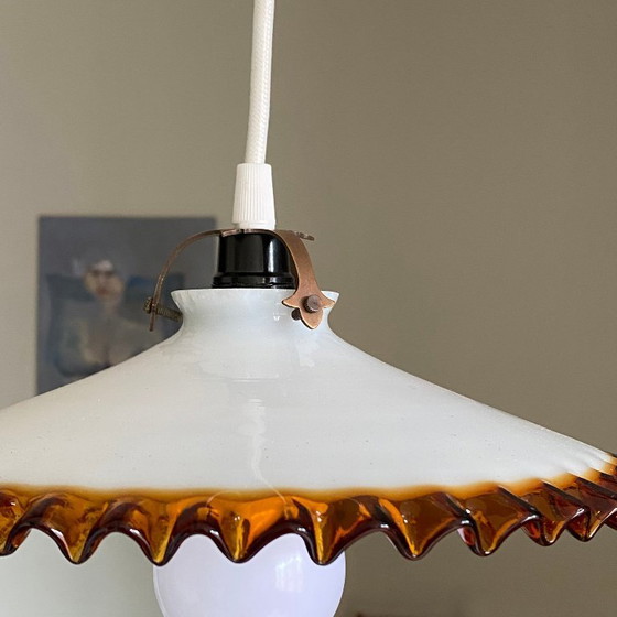 Image 1 of Antique pendant light with a white opaline glass shade and a golden caramel wavy edge