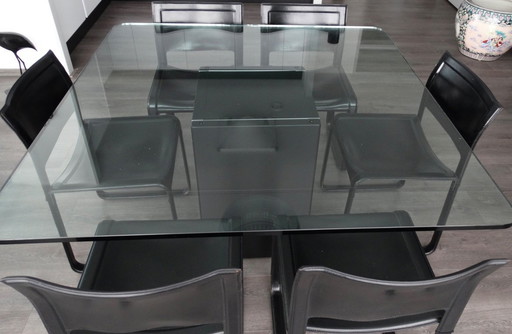 Tavolo da conferenza in vetro con 8 sedie in pelle e lampada ad arco abbinata.