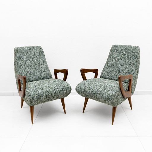 Een paar Italiaanse fauteuils in mid-century modern stijl met sculpturale houten armleuningen.