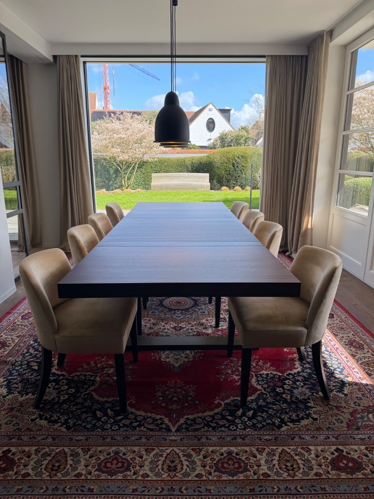 Mesa de comedor a medida en madera de macasar, combinada con 8 sillas de comedor y alfombra iraní a juego.