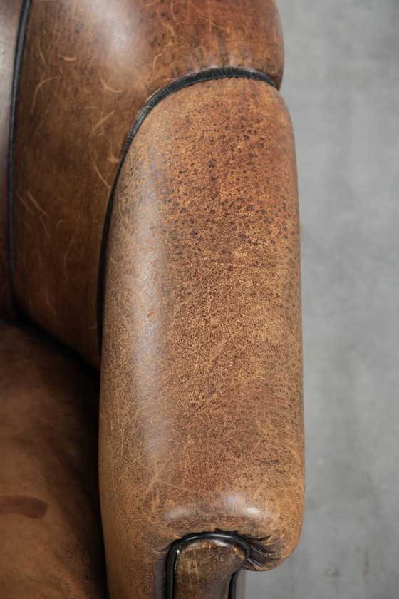 Image 1 of Leuke vintage schapenleren clubfauteuil in Engelse stijl met zwarte biezen