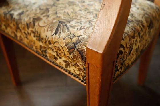 Image 1 of Vintage salonfauteuil met bloemenpatroon op de bekleding en sierlijke armleuningen.
