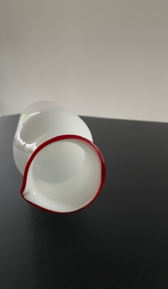 Image 1 of Caraffa dal design scandinavo in vetro bianco con bordo rosso.