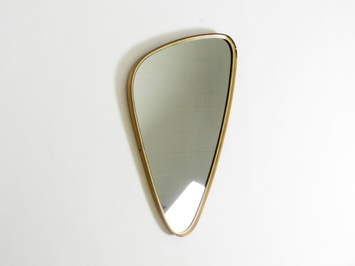 Beautiful heavy mid-century brass kidney-shaped wall mirror from Münchner Zierspiegel