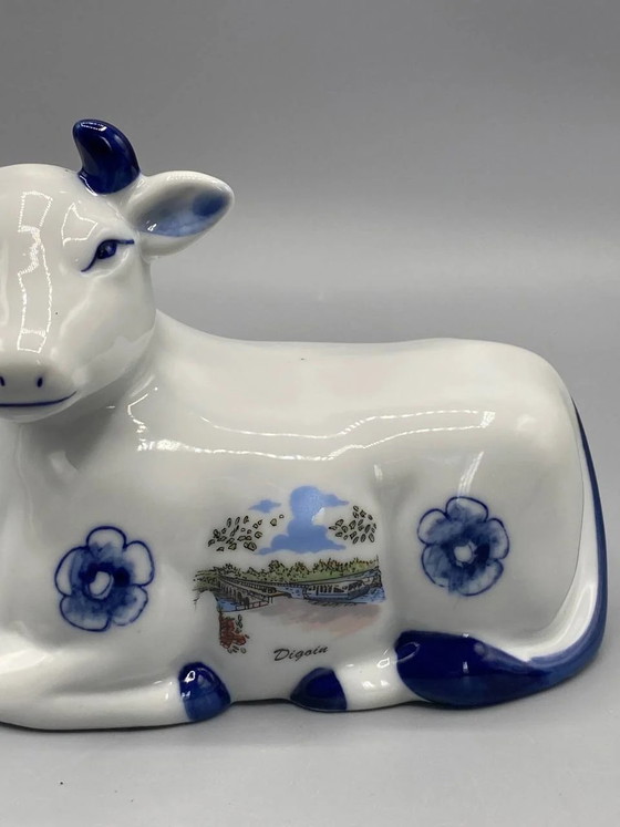 Weiße und blaue Fayence-Figur einer liegenden Kuh, Digoin Souvenir – Geschirr (photo 2 of 7)