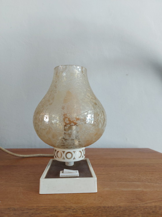 Image 1 of vintage tafellamp met een witte basis en een kap van gestructureerd, amber glas. 