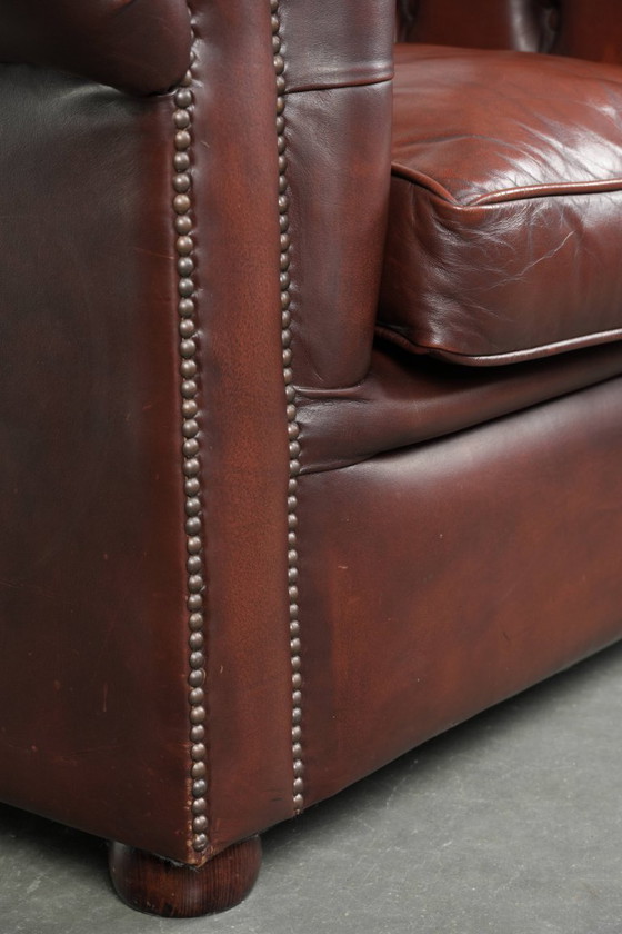 Image 1 of Beautiful red/brown cowhide Chesterfield armchair in a classic English style
