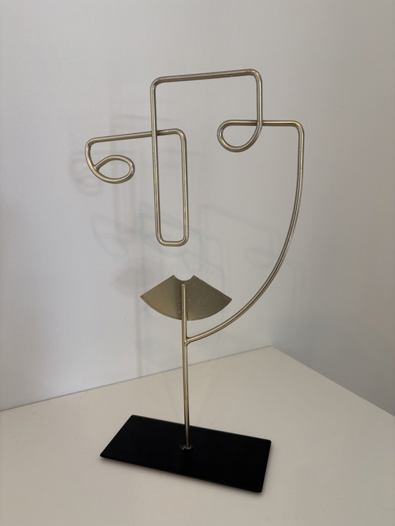 Image 1 of Scultura moderna in filo metallico raffigurante un volto stilizzato, di colore oro