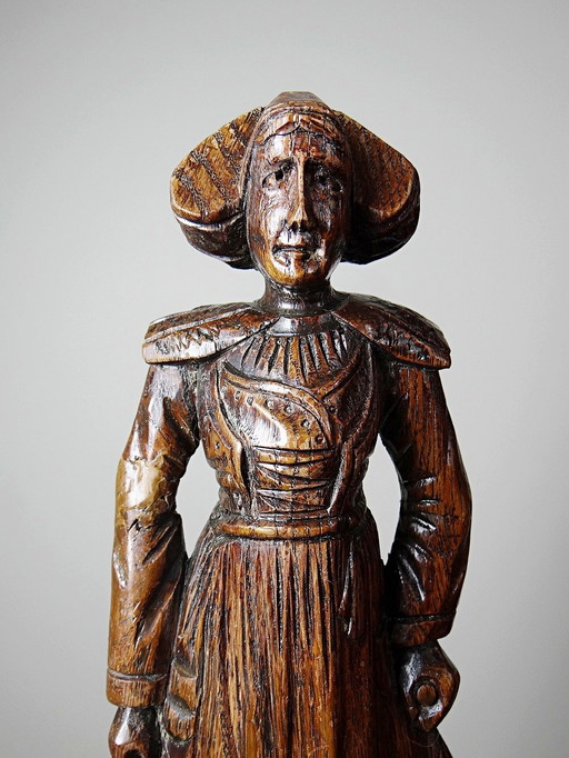 Antique wooden statue of a Breton woman in traditional dress