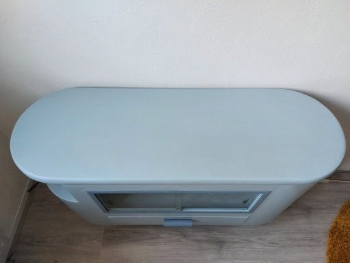 Sideboard with glass sliding doors and rounded shapes